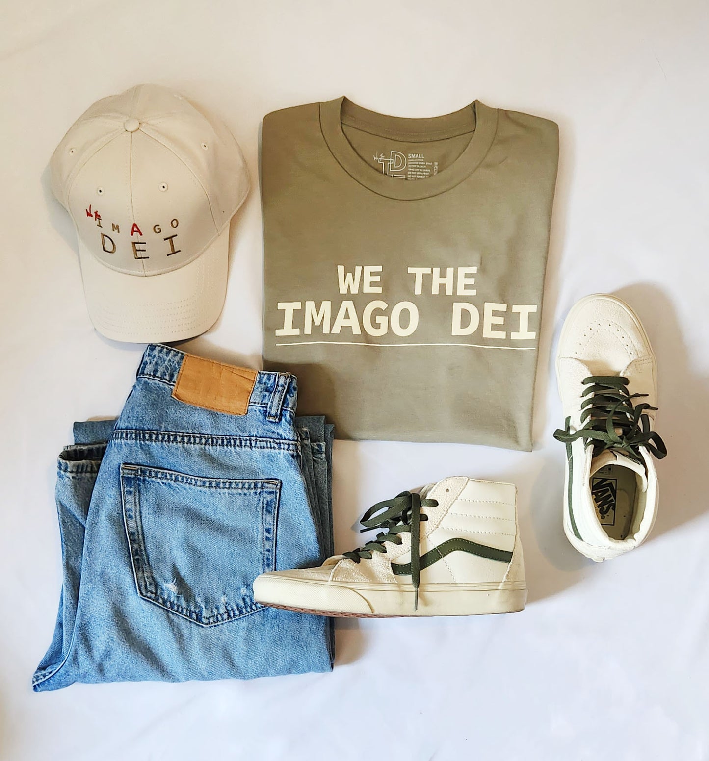 green tee flatlay with cap and jeans